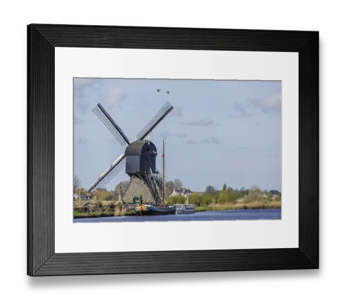 Framed Print : Windmill on the river bank with boats and grasses in the foreground