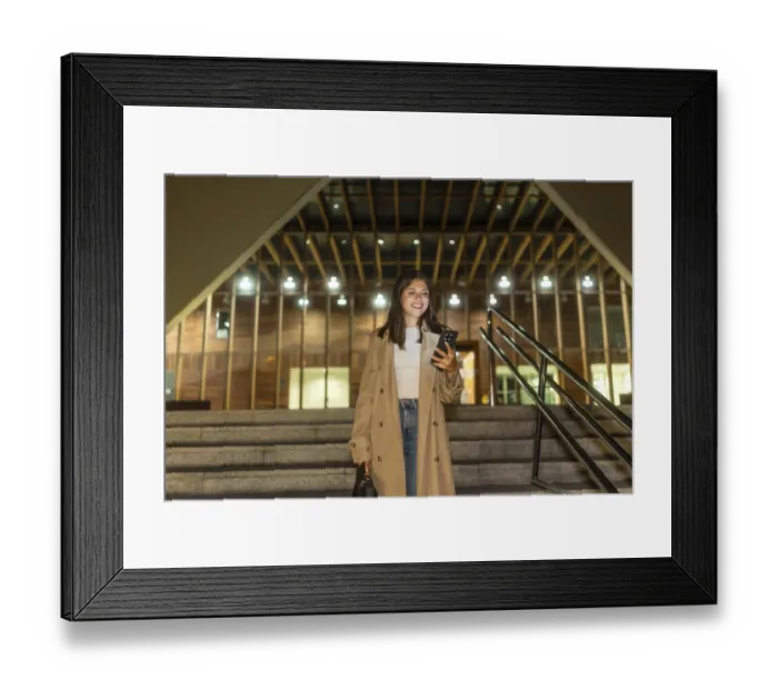 Framed Print : Young woman smiling while checking her smartphone Framed Print : Young woman smiling while checking her smartphone
