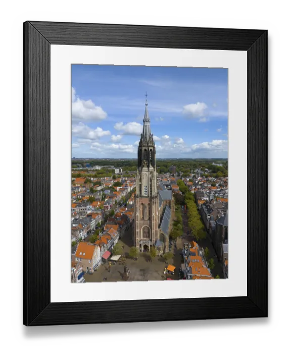 Framed Print : Aerial view of a church tower in the middle of a busy city with red roofs