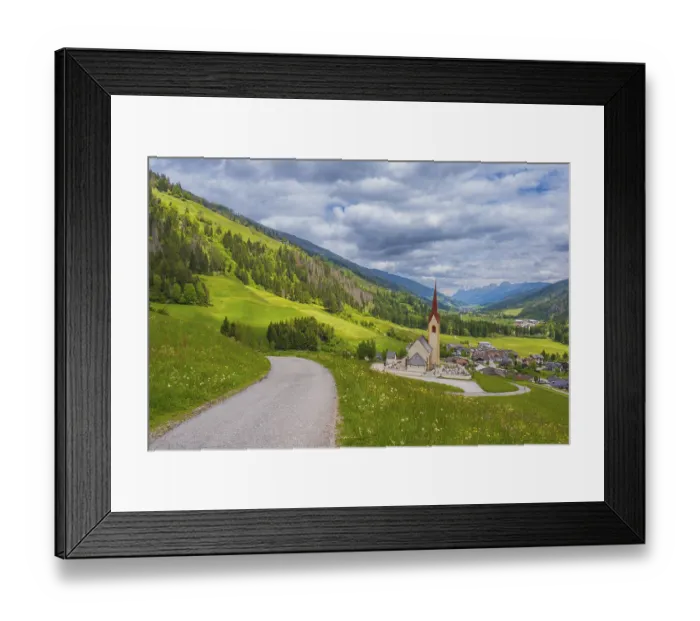 Framed Print : View along a road to the church of Winnebach with the valley behind it