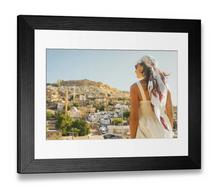 Framed Print : Traveler woman in white dress looking over panoramic view of historic city of Mardin Turkey with mosque minarets