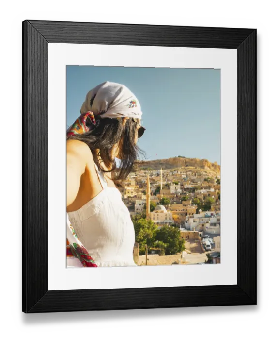 Framed Print : Traveler woman in white dress arms taking selfie self-portrait ooking over panoramic view of historic city of Mardin