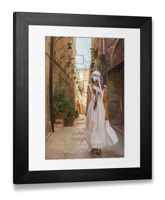 Framed Print : Traveler woman in white dress walking through narrow stone alley in historic city of Mardin Turkey with traditional Framed Print : Traveler woman in white dress walking through narrow stone alley in historic city of Mardin Turkey with traditional