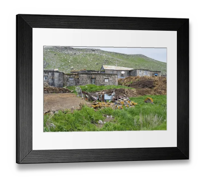 Framed Print : Stone house in a rural area surrounded by green hills and rocks