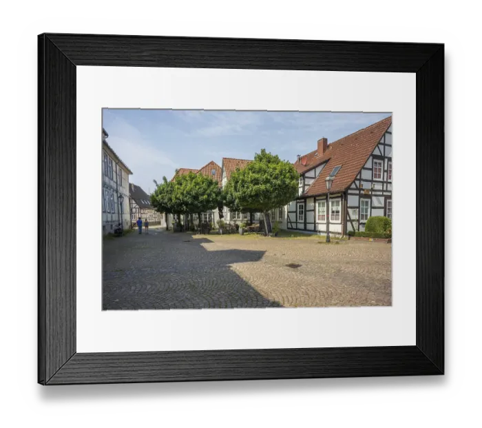 Framed Print : Paved courtyard with traditional half-timbered houses and trees