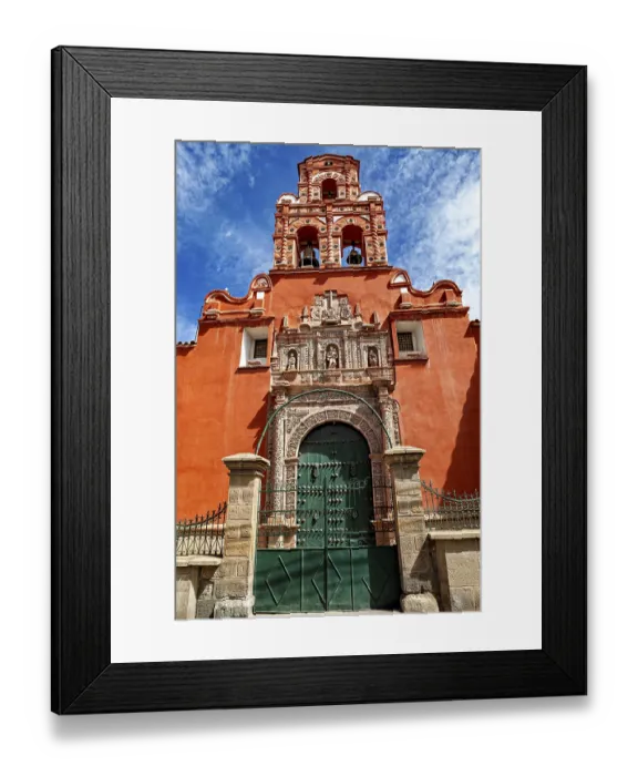 Framed Print : Door of a colonial building with red facade and bell tower under a clear blue sky