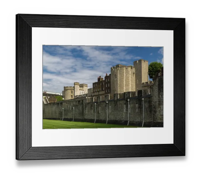 Framed Print : Historic stone structure under a vibrant blue sky with clouds at The Tower of London