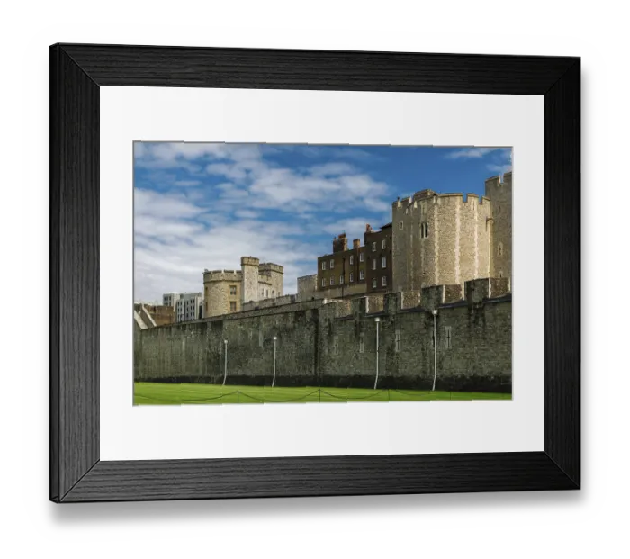 Framed Print : Stone fortress with green lawn under a bright blue sky with clouds at The Tower of London Framed Print : Stone fortress with green lawn under a bright blue sky with clouds at The Tower of London