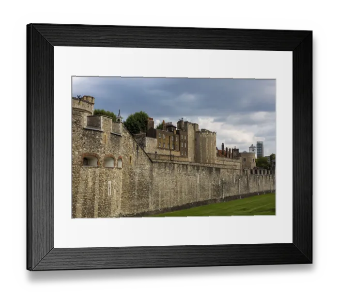 Framed Print : Historic stone walls of a fortification under a cloudy sky at The Tower of London