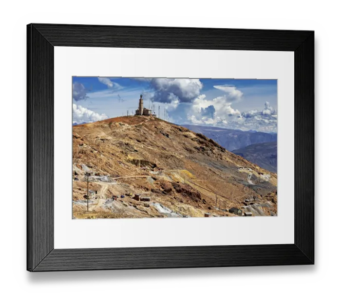 Framed Print : Single building with antennas on a bare hill under a dramatic sky