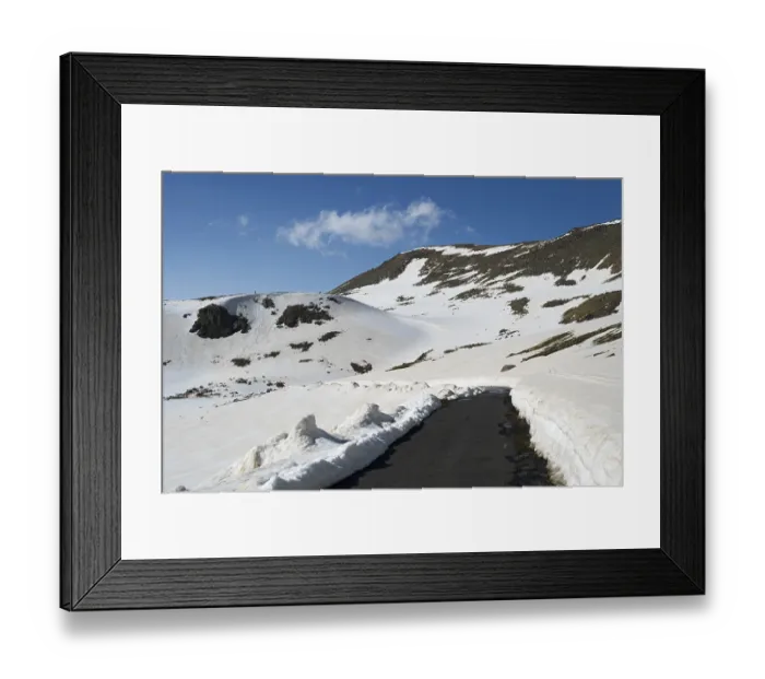 Framed Print : Winter landscape with snow-covered mountains and a paved road Framed Print : Winter landscape with snow-covered mountains and a paved road