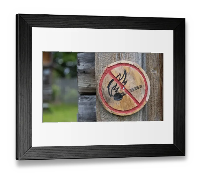 Framed Print : Brennendes Streichholz, kleine runde Holztafel mit aufgemaltem Verbotssymbol gegen das Entfachen von Feuer