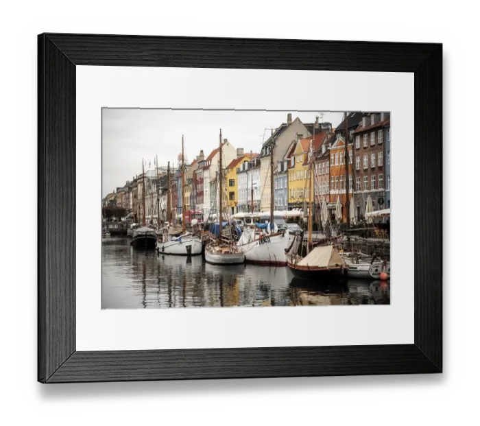 Framed Print : Harbor scene with boats lined up beside vibrant buildings and reflections in the water in Nyhavn Framed Print : Harbor scene with boats lined up beside vibrant buildings and reflections in the water in Nyhavn