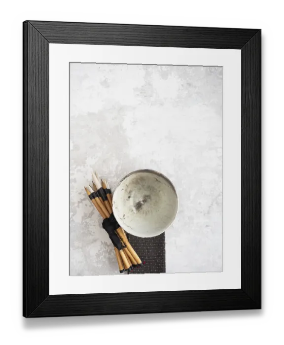 Framed Print : Calligraphy brushes tied with black ribbon and ceramic bowl resting on textured surface