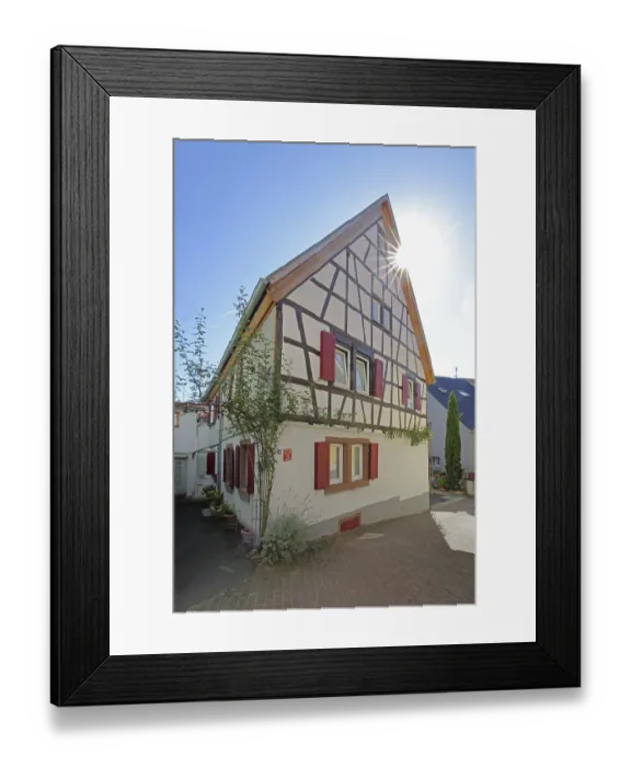 Framed Print : Half-timbered house with red shutters against the light