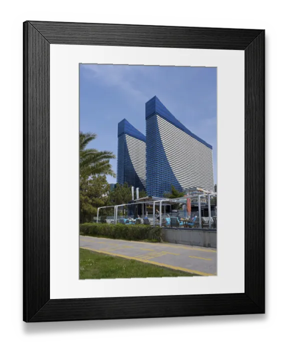 Framed Print : Two tall blue buildings with modern architectural features and a terrace in an urban environment