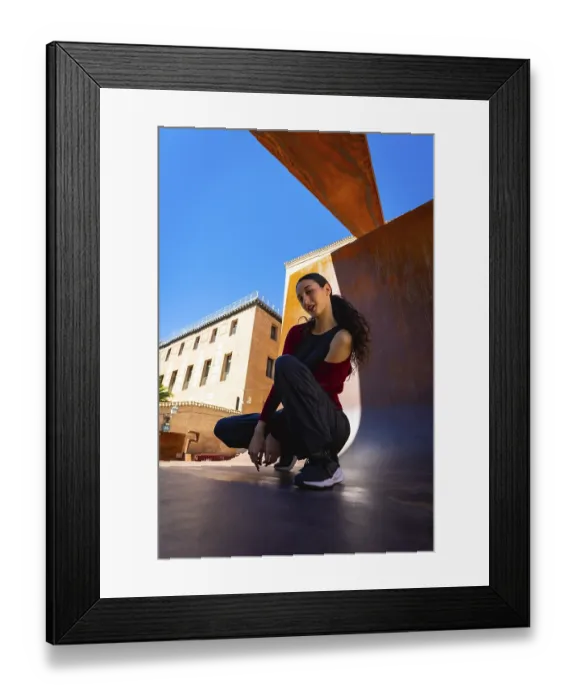 Framed Print : Young woman squatting on an urban surface Framed Print : Young woman squatting on an urban surface