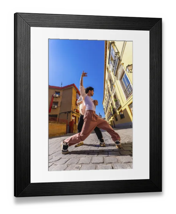Framed Print : Two young men engaging in an energetic dance performance on a sunny historic cobblestone street