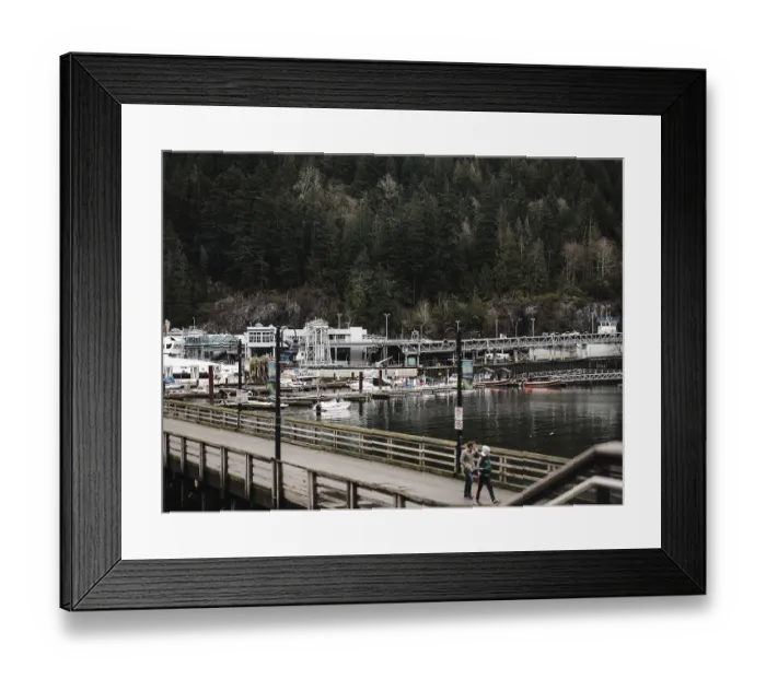 Framed Print : Boats docked alongside a wooden pier with a backdrop of dense forest in Horseshoe Bay