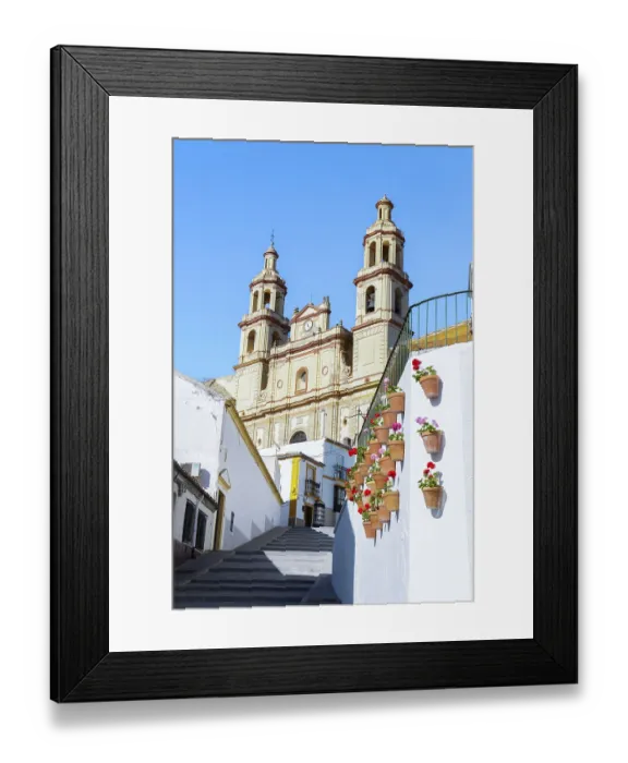 Framed Print : Village street leading up to the church of Our Lady of the Incarnation against a blue sky in olvera