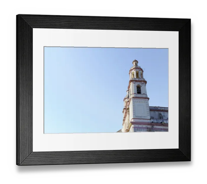 Framed Print : Olvera church bell tower rising against a clear blue sky in olvera