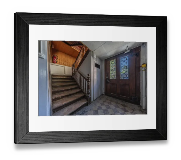 Framed Print : Staircase with main entrance door of a multi-storey residential building built in 1903 in front of demolition work