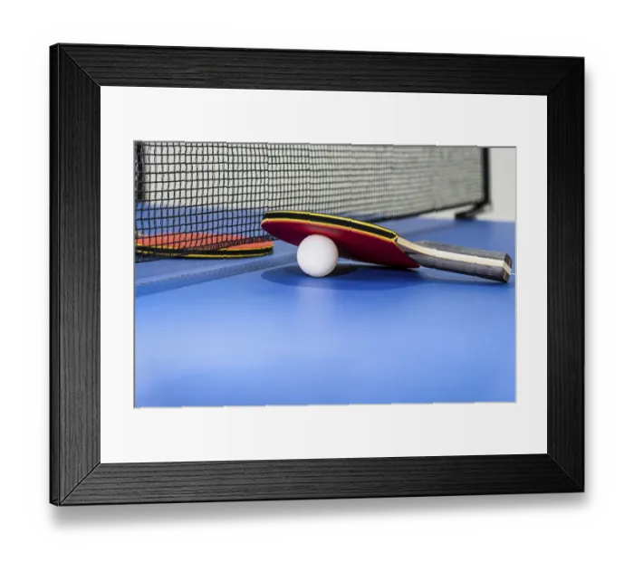 Framed Print : Red table tennis racket and a white ball on the blue ping pong table with a black net