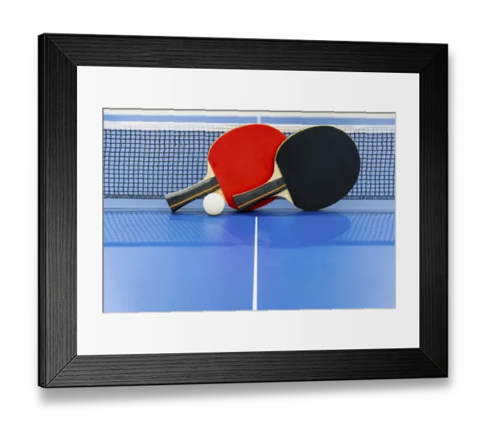 Framed Print : Black and red table tennis racket and a white ball on the blue ping pong table with a net Framed Print : Black and red table tennis racket and a white ball on the blue ping pong table with a net