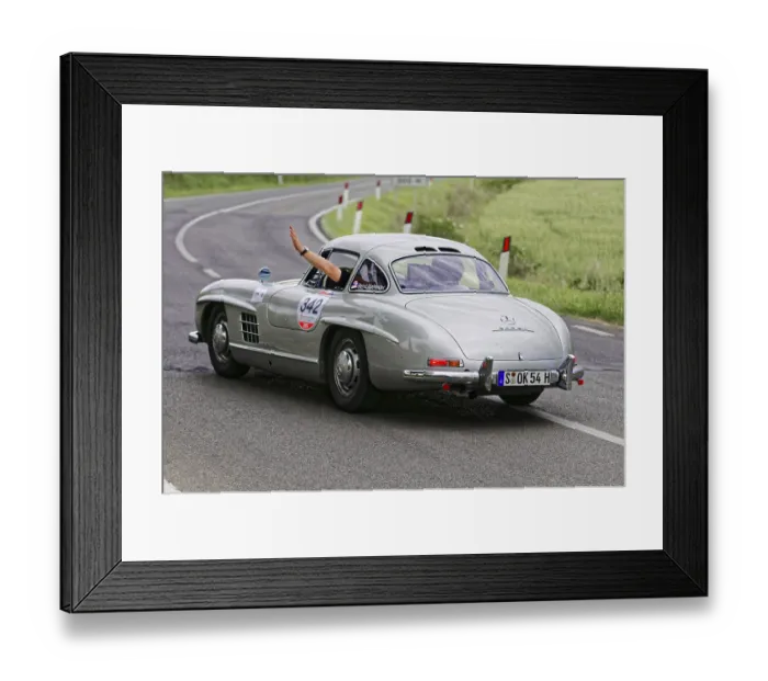 Framed Print : Silver retro sports car turns off on a winding road