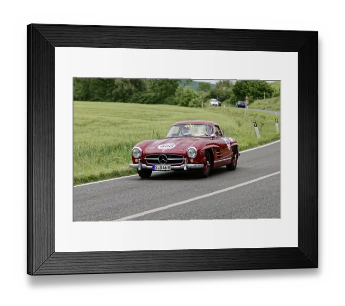 Framed Print : A red Mercedes classic car drives along a picturesque country road surrounded by trees