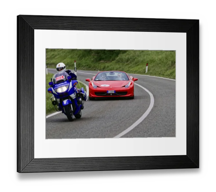Framed Print : Blue motorbike overtakes red Ferrari convertible on winding road