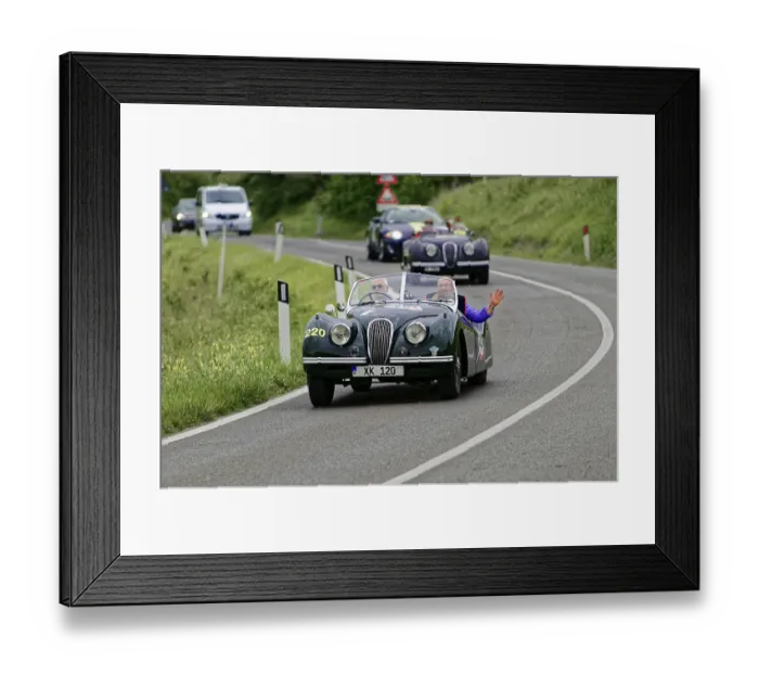 Framed Print : Two people in a green vintage convertible on a winding country road