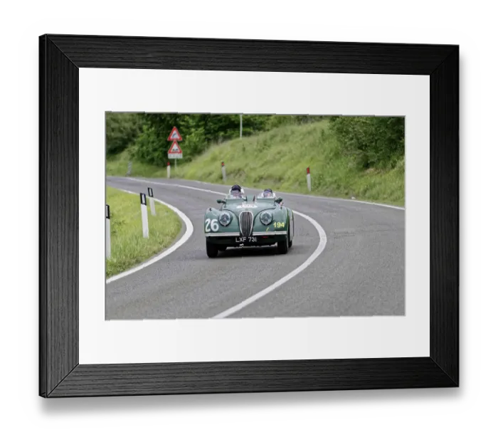 Framed Print : Two people in a green vintage convertible with racing numbers