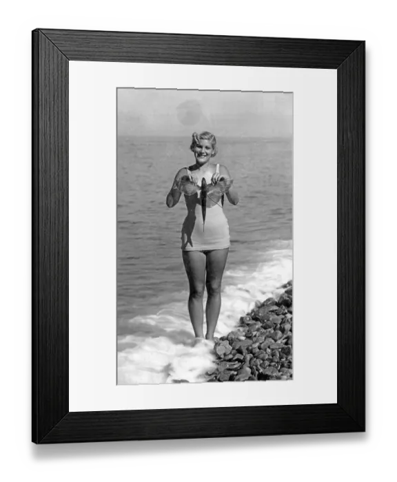 Framed Print : Woman on the beach in a bathing suit with flying fish