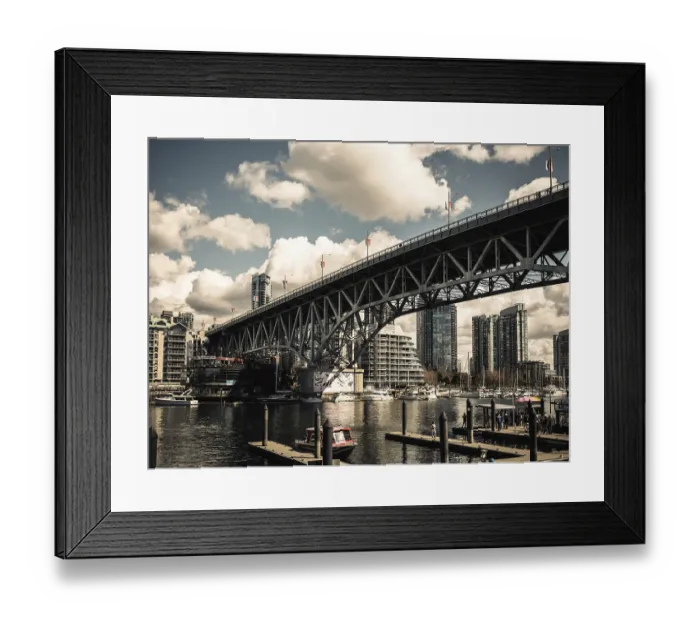 Framed Print : A grand bridge stretches over a busy harbor against a backdrop of clouds in Vancouver