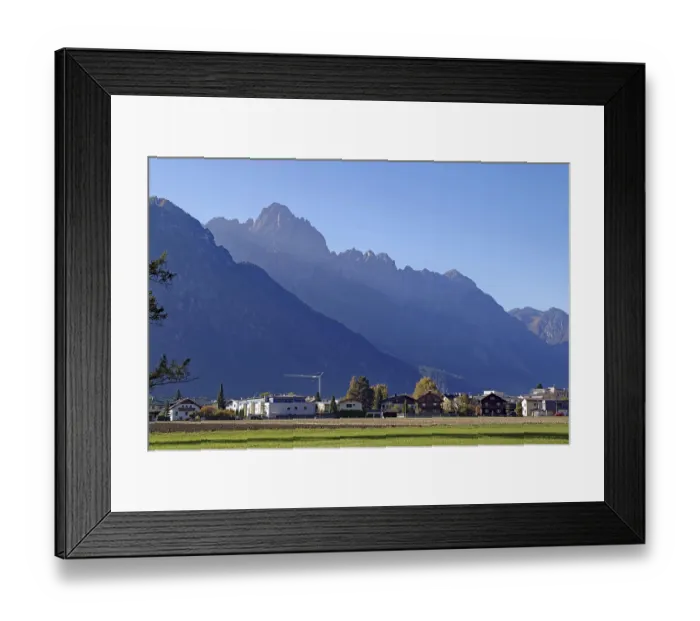 Framed Print : Village at the foot of rugged mountains