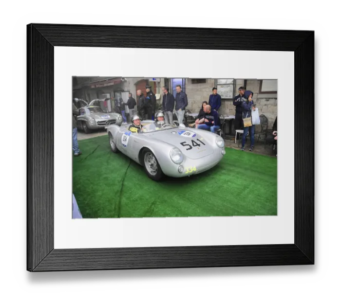 Framed Print : Silver Porsche 550 Spyder with two helmeted drivers drives across the green carpet at the rally Framed Print : Silver Porsche 550 Spyder with two helmeted drivers drives across the green carpet at the rally