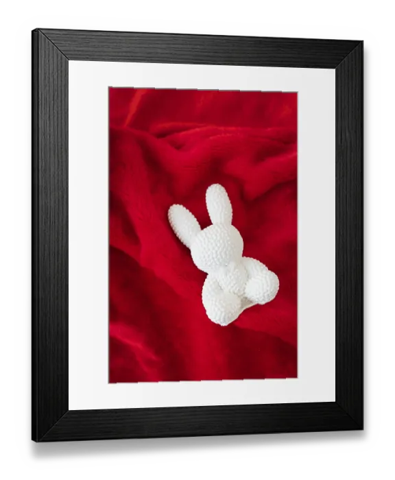 Framed Print : A red ceramic white rabbit lies on a red background Framed Print : A red ceramic white rabbit lies on a red background