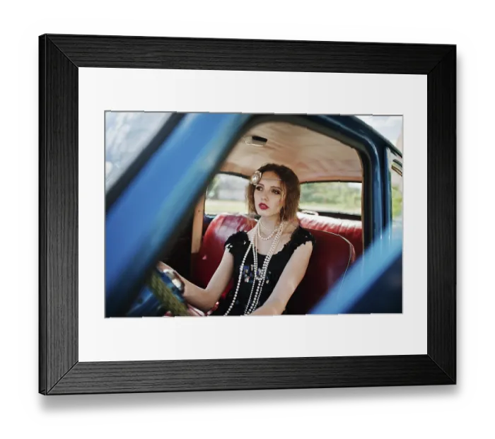 Framed Print : Portrait of beautiful curly fashion girl model with bright makeup in retro style sitting on a vintage car