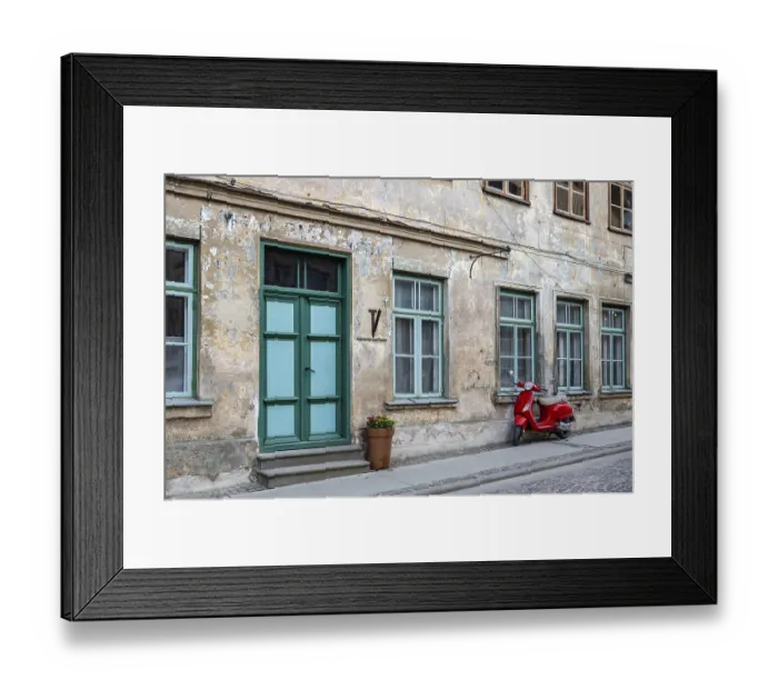 Framed Print : A red vintage scooter on a pedestrian sidewalk in front of an old stone house Framed Print : A red vintage scooter on a pedestrian sidewalk in front of an old stone house
