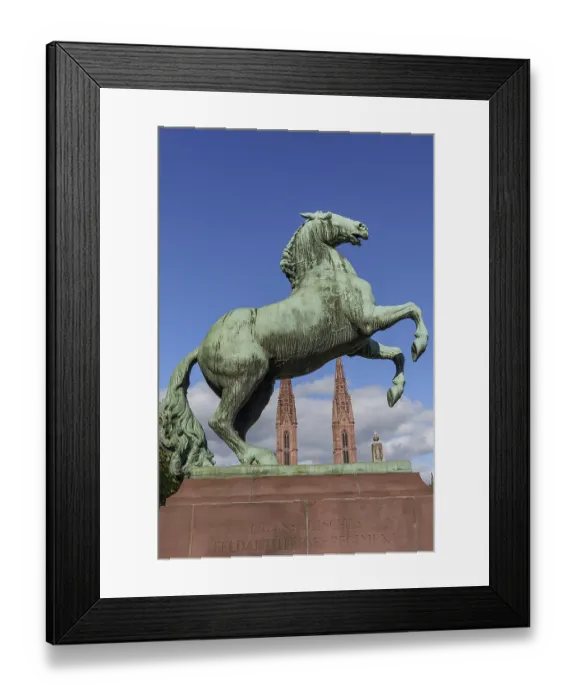 Framed Print : Bronze monument of a climbing horse in front of a neo-Gothic church Framed Print : Bronze monument of a climbing horse in front of a neo-Gothic church