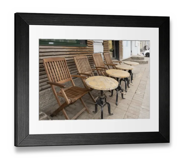 Framed Print : Tables and chairs in a street cafe