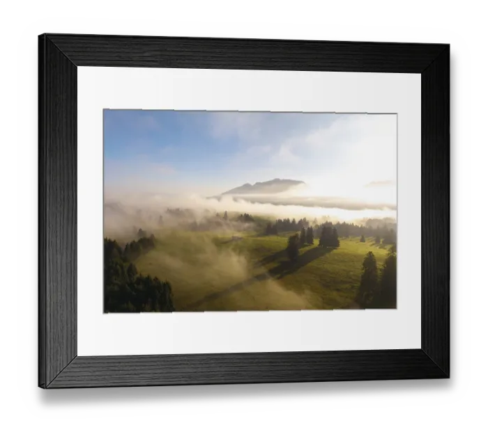 Framed Print : Landscape at sunrise with fog over a green meadow and mountains in the background Framed Print : Landscape at sunrise with fog over a green meadow and mountains in the background