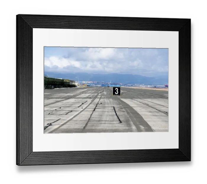 Framed Print : Gibraltar, BOTC - BOTC - 06-03-2024: Airport taxiway in Gibraltar with markings and mountains in the background