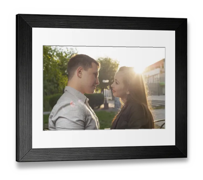 Framed Print : Cute Caucasian couple pose for the camera outdoors with town on background