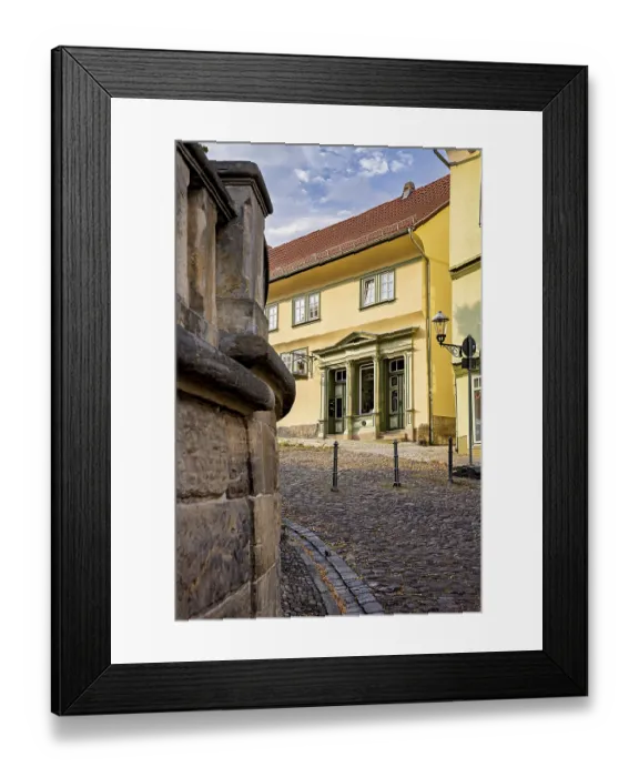 Framed Print : Yellow historic building on a paved street with classic architecture