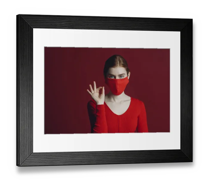 Framed Print : Studio portrait ok sign of young woman in protective medical face mask isolated on red background