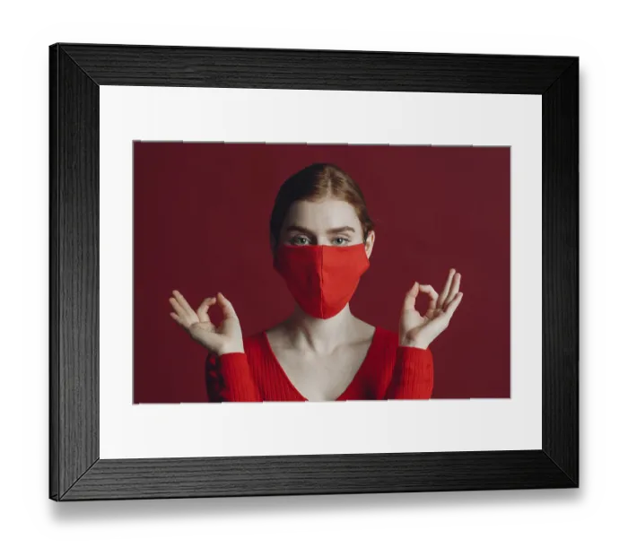 Framed Print : Studio portrait of young woman in protective medical face mask isolated on red background