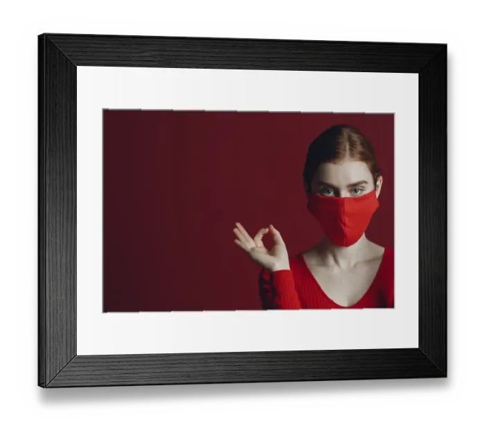 Framed Print : Studio portrait of young woman in protective medical face mask isolated on red background