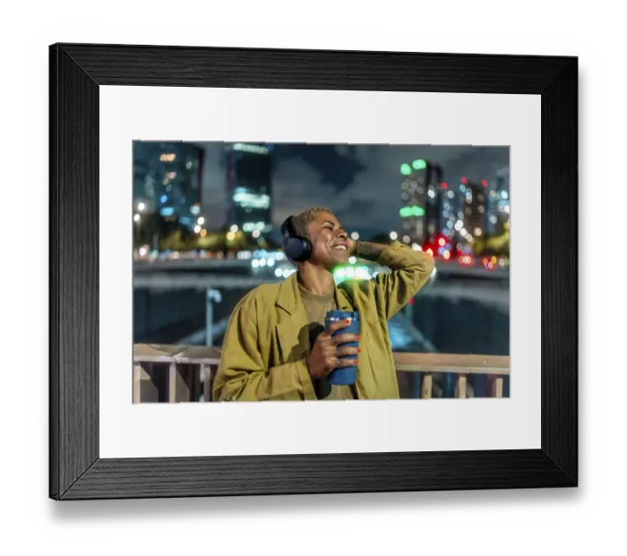 Framed Print : Happy black woman relaxing in a vibrant city at night